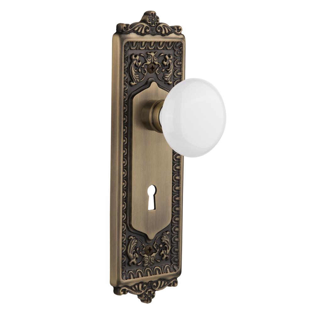 Nostalgic Warehouse EADWHI Mortise Egg and Dart Plate with White Porcelain Knob and Keyhole in Antique Brass